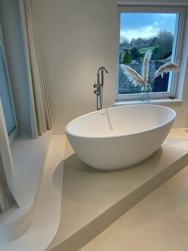 Freistehende Badewanne auf fugenlosem Podest und Boden